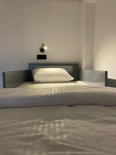 a bedroom with a large white bed with a light above it at Journey Junction Hostel in Nuwara Eliya