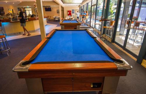 a large blue and white swimming pool in a building at Settlers Inn in Port Macquarie