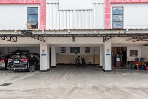 a garage with two cars parked in it at Hotel O Ilir Barar I Near Rumah Sakit Islam Siti Khadijah Formerly Maleo Hotel in Palembang