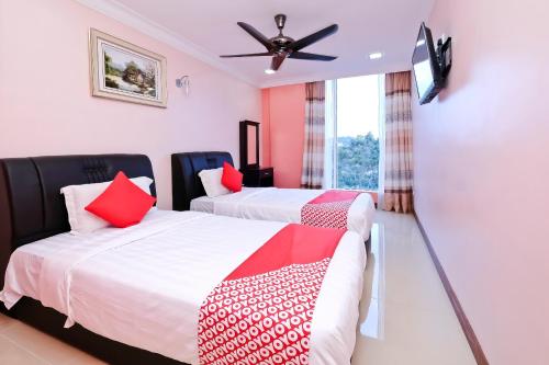a bedroom with two beds and a ceiling fan at OYO 714 Arina Hotel in Bangi