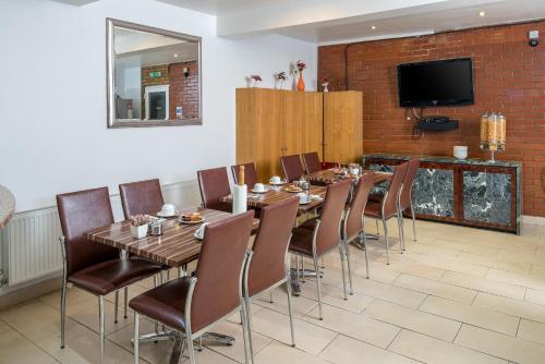 a dining room with a long table and chairs at OYO Abbey Hotel, London Shepherd's Bush Market in London
