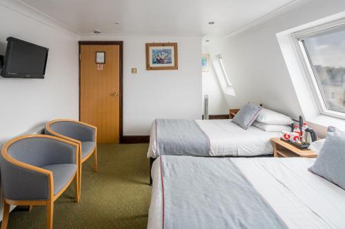 a hotel room with two beds and a tv at OYO Abbey Hotel, London Shepherd's Bush Market in London