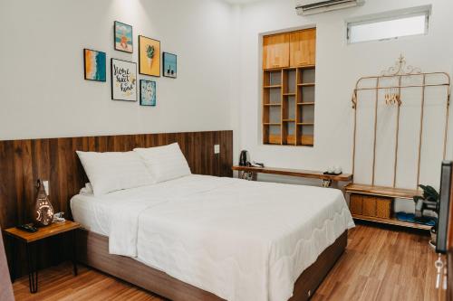 a bedroom with a large white bed and a window at LA MER Homestay Quynhon in Quy Nhon
