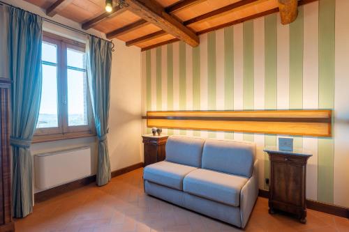 a living room with a chair and a window at Locanda Poggioleone in Castiglione del Lago