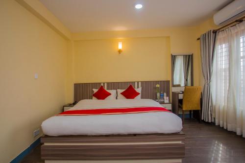 a bedroom with a large bed with red pillows at OYO 297 Hotel Aayam in Kathmandu