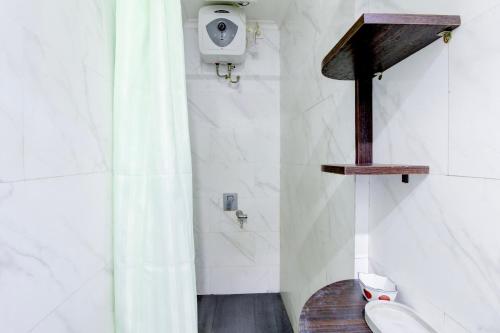a bathroom with a shower with a toilet and a sink at Hotel O Jalan Jenderal Sudirman Near Imam Bonjol Square in Padang