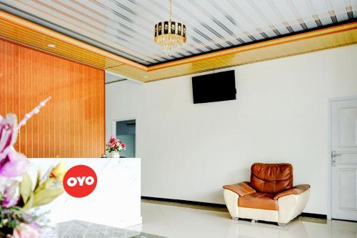 a living room with a couch and a chair at Hotel O Padang City Center Near Pantai Padang Formerly Hotel Siti Nurbaya in Padang
