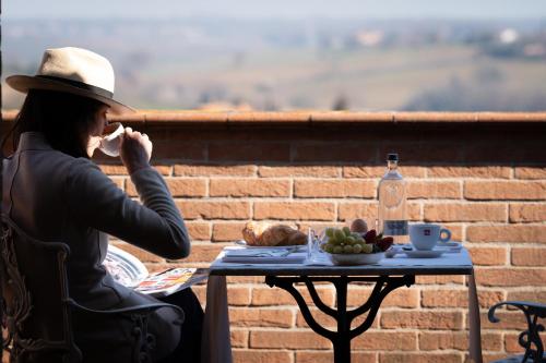 a woman sitting at a table talking on a cell phone at Locanda Poggioleone in Castiglione del Lago