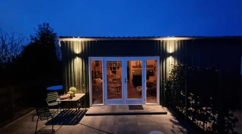a house with a patio at night with a blue light at Artisan Hideaway Bed and Breakfast in Breezand