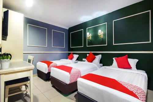 a bedroom with two beds with red and white sheets at OYO 761 City Hotel in Kuala Lumpur