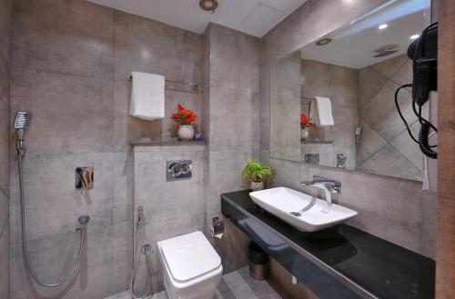 une salle de bain avec un lavabo, une douche et des toilettes dans l'établissement TreeHouse Stamp Amritsar, à Amritsar
