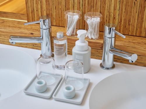 a bathroom sink with a bottle of soap and glasses at LUXE TECH VILLA Ashitoku - Vacation STAY 10822v in Akaoki