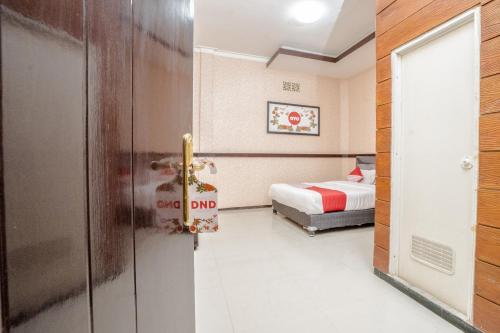 a hotel room with a bed and a door at Hotel O Central Batu Near Jatim Park 3 Formerly Bunga Matahari Hotel in Batu