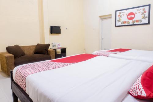 a hotel room with a bed and a couch at Hotel O Central Batu Near Jatim Park 3 Formerly Bunga Matahari Hotel in Batu