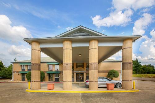 a hotel with a car parked in front of a building at OYO Hotel Texarkana Trinity AR Hwy I-30 in Texarkana