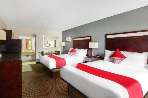 a hotel room with two beds and a flat screen tv at OYO Hotel Texarkana Trinity AR Hwy I-30 in Texarkana