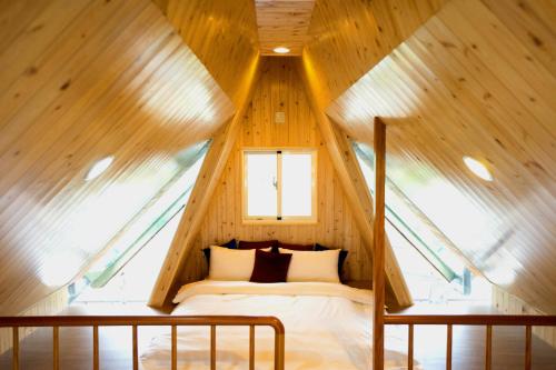 a bedroom in a tree house with a bed in it at Artisan Hostel in Toucheng