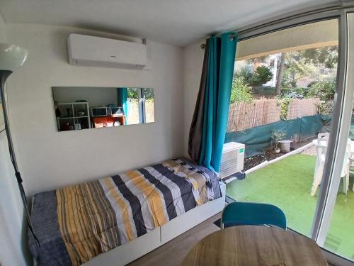 une chambre avec un lit, une table et une fenêtre dans l'établissement Le Lagos 3 min mer clim Jardin parking, à Saint-Mandrier-sur-Mer