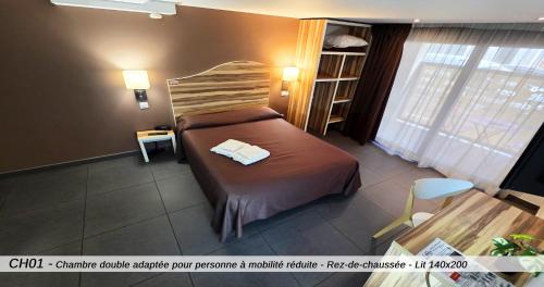 a bedroom with a bed in a room with a window at Hôtel Au Valéry in Sète