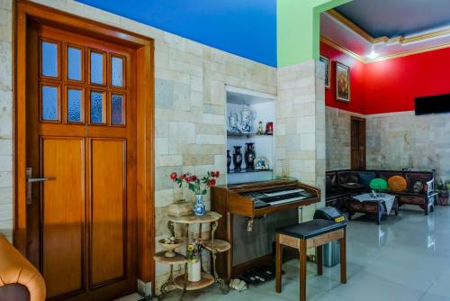 a living room with a wooden door and a table at Hotel O Guest House Amalia Malang in Malang