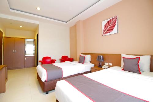 a hotel room with two beds with red chairs at Collection O Pasteur Near Paris Van Java Mall Formerly Sweet Karina in Bandung