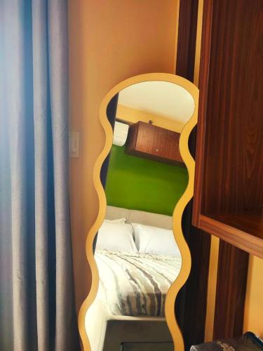 a small bedroom with a bed with a mirror at Timbi Suites Mactan in Lapu Lapu City