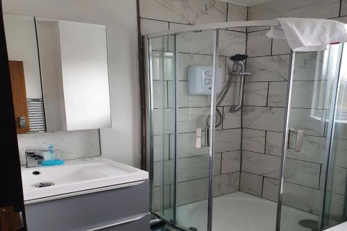 a bathroom with a shower and a sink at Devine Beach Hotel, Westcliff Southend-On-Sea in Southend-on-Sea