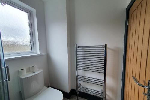a bathroom with a white toilet and a window at Devine Beach Hotel, Westcliff Southend-On-Sea in Southend-on-Sea