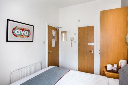 a hotel room with a bed and a door and a room at OYO London Guest House in London