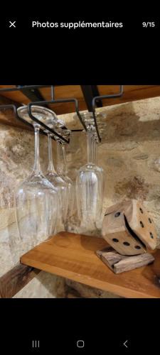 quatre verres à vin assis sur une étagère en bois dans l'établissement Le petit bourguignon, à Dijon