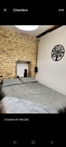 une chambre avec un lit et un mur de briques dans l'établissement Le petit bourguignon, à Dijon