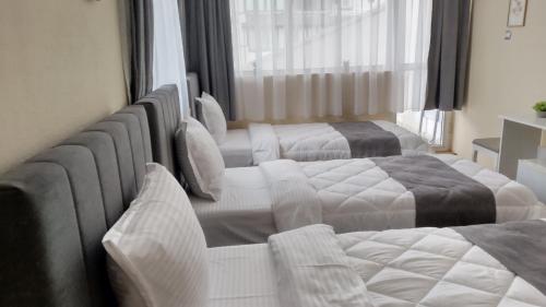 a hotel room with three beds and a window at Victoria Family Hotel in Balchik