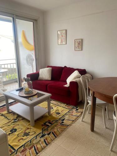 un salon avec un canapé rouge et une table dans l'établissement 3 rooms near the beaches, à Six-Fours-les-Plages