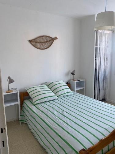 - une chambre avec un lit aux rayures vertes et blanches dans l'établissement 3 rooms near the beaches, à Six-Fours-les-Plages