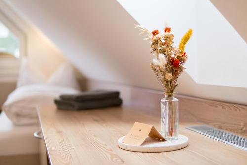 a table with a vase of flowers and a note at Pension Zum Schrammel in Altdorf bei Nuernberg