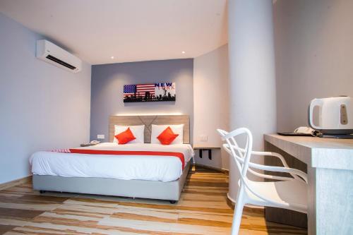 a bedroom with a bed and a desk with a tv at Hotel O Gs Hotels Near Strand Mall in Kota Damansara