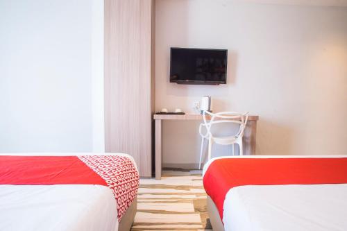 a room with two beds and a desk and a television at Hotel O Gs Hotels Near Strand Mall in Kota Damansara