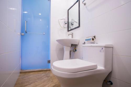 a bathroom with a toilet and a sink and a mirror at Hotel O Gs Hotels Near Strand Mall in Kota Damansara