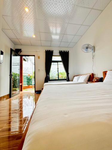a bedroom with two beds and a window at Bình Minh Homestay - Dốc Lết in Doc Let