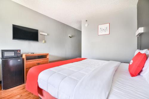 a bedroom with a bed and a flat screen tv at OYO Townhouse Inn Jacksonville near Little Rock Air Force Base in Jacksonville