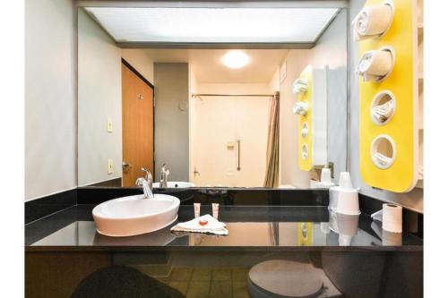 a bathroom with a sink and a large mirror at OYO Townhouse Inn Jacksonville near Little Rock Air Force Base in Jacksonville