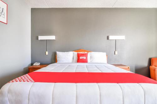 a bedroom with a red and white bed with two lamps at OYO Townhouse Inn Jacksonville near Little Rock Air Force Base in Jacksonville
