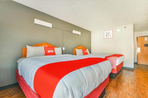 a bedroom with two beds with red and white sheets at OYO Townhouse Inn Jacksonville near Little Rock Air Force Base in Jacksonville