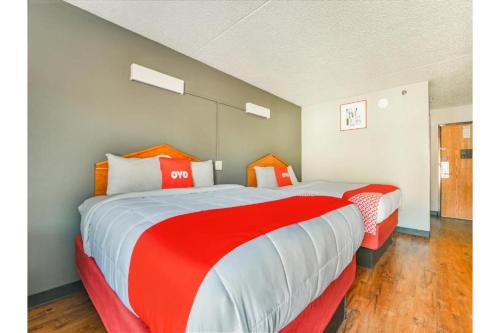 a bedroom with two beds with red and white sheets at OYO Townhouse Inn Jacksonville near Little Rock Air Force Base in Jacksonville