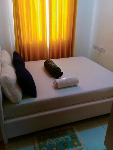 a bed with two pillows sitting on top of it at ANM Buxton Point Apartment in Mombasa