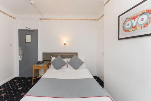 a bedroom with a bed and a table in a room at OYO Stade Court Hotel in Hythe