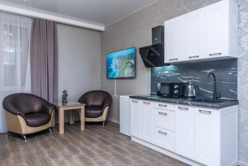 a kitchen with white cabinets and a table and two chairs at Viktoriya Family 2 Country complex in Kyiv