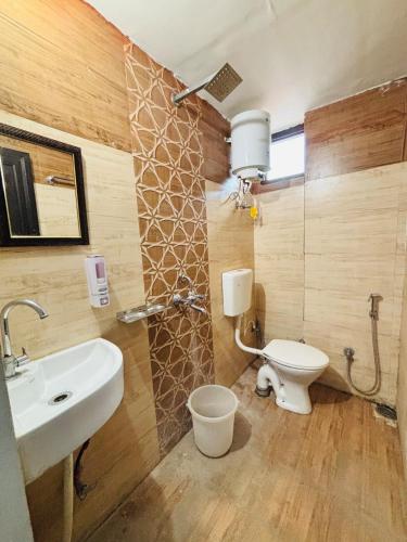 a bathroom with a white sink and a toilet at Tulsi Homestay- Home away from home in Haldwāni