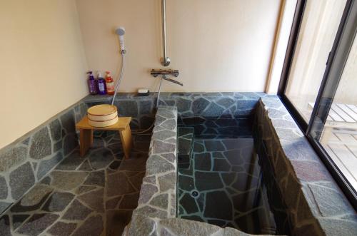 屋久島にあるCottage Viewsのバスルーム(バスタブ、シャワー、スツール付)