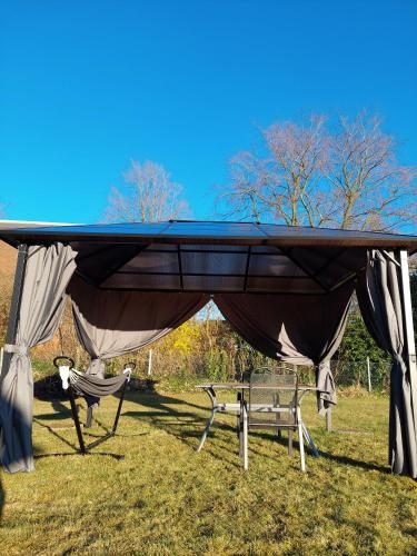 a pavilion with a table and chairs in a field at Cozy Home in der Heide, zentral und ruhig in Schneverdingen